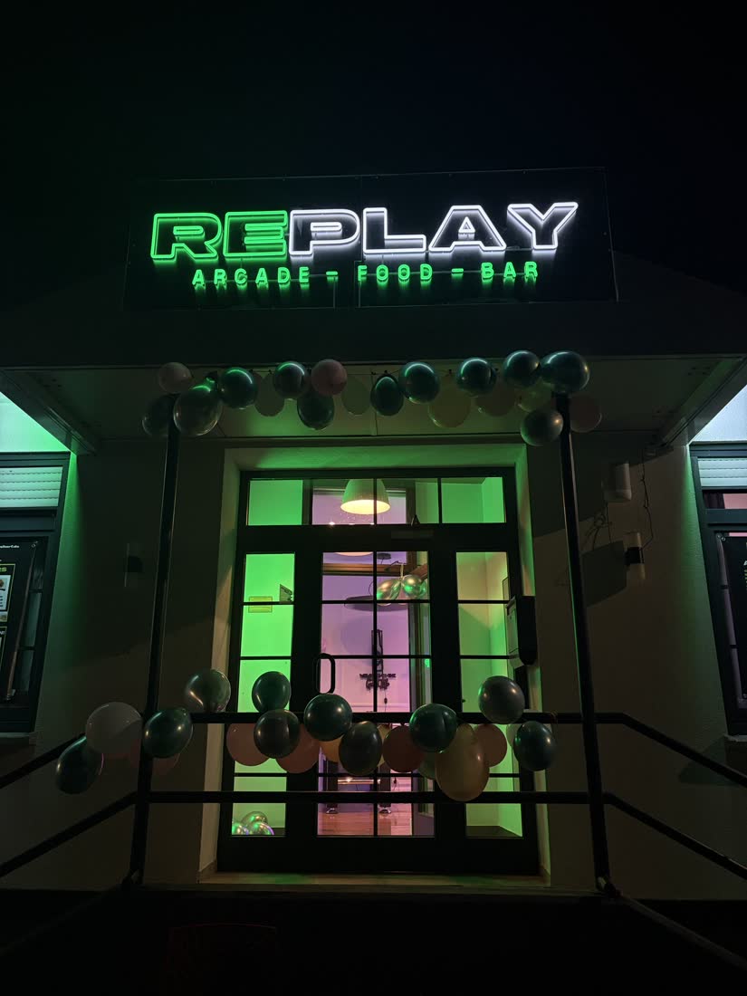 Replay Eitorf am Abend mit grün leuchtendem Neon-Schild